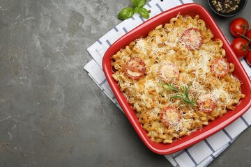 Delicious al forno pasta in baking dish on grey table, flat lay. Space for text