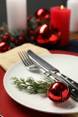 Christmas place setting with plates, cutlery and festive decor on table, closeup