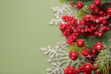 Fir tree branches and Christmas decor on green background, closeup. Space for text