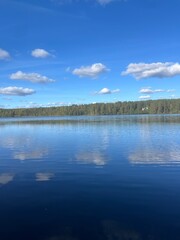beautiful blue lake view, blue sky with white clouds reflections on the lake surface