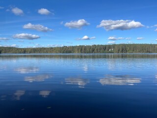 beautiful blue lake view, blue sky with white clouds reflections on the lake surface