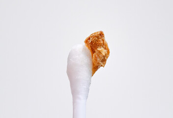 Ear wax plug isolated on white background. Removed giant ear wax plug on cotton swab closeup. Wax,...