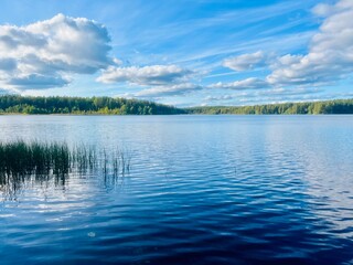 beautiful blue lake view, blue sky with white clouds reflections on the lake surface