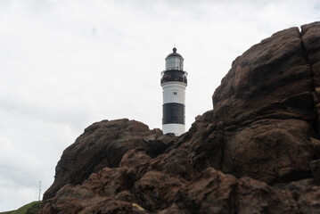 Low view of the Barra Lighthouse, during a cloudy day, located in the Barra neighborhood in the city of Salvador, Bahia.