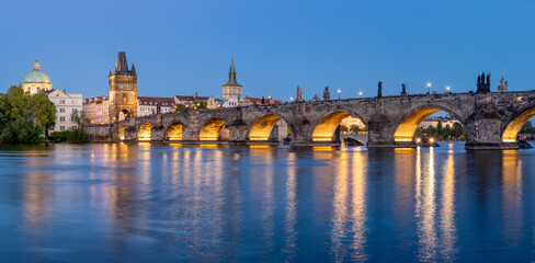 Charles Bridge (Karlův most) over Vltava river, illuminated in the evening, Prague, Czech Republic