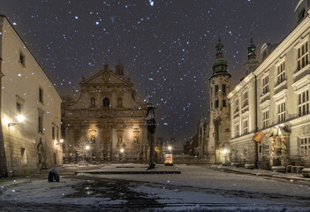 Romanesque St Andrew and baroqe St Peter and Paul churches on Kanonicza street during snowy night,...