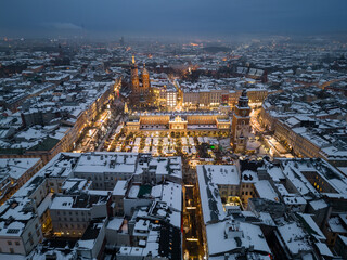 Night view of snow covered Main Square with Christmas Fairs in Krakow, Poland