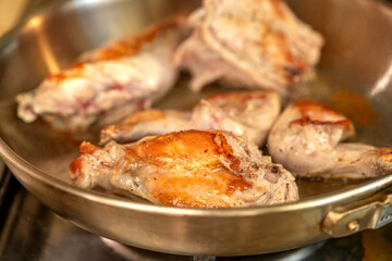 Portions of rabbit meat are fried in a frying pan closeup