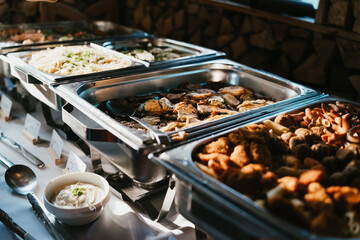 Elegant Metal Buffet Trays Displaying a Variety of Foods at an Evening Event