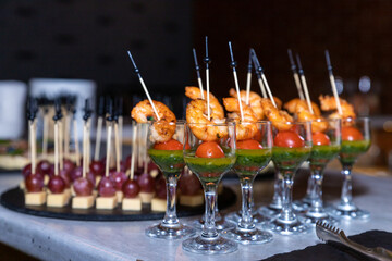 catering buffet with variety of snacks and appetizers at luxury event.Tasty canapes with shrimps, vegetables and cream cheese.