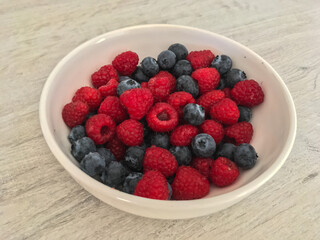 Close-up tasty ripe fresh summer berries - raspberry and blueberry