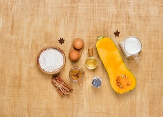 Ingredients for making pumpkin muffins or donuts on light wooden background. Baking recipes with pumpkin. Autumn recipes.