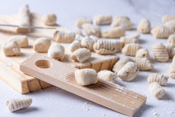 Detail of gnocchi preparation with wooden utensil.