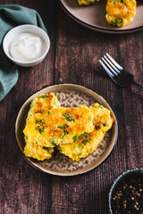 Crispy potato fritters with broccoli on a plate on the table vertical view