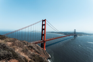 The Golden Gate Bridge spans across the water, with the skyline of San Francisco visible in the...