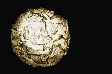   circle of crumpled paper on a dark background