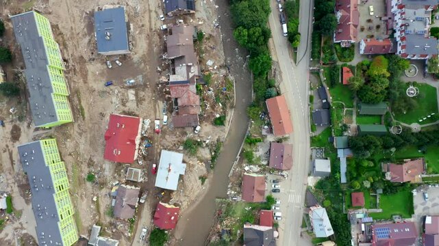 Aerial view of natural disaster - floods in southern Poland in 2024. Washed-out roads, destroyed houses, and damaged infrastructure. 4K drone wide shot