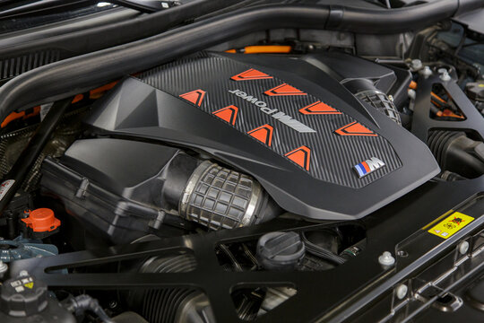 BMW XM engine - hybrid, plug-in V8 engine. Engine motor M POWER of BMW XM 50e close-up with emblem. BMW sport engine or motor under vehicle hood.