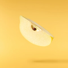 Fresh ripe yellow Quince fruit  falling in the air isolated on yellow background. Food levitation...