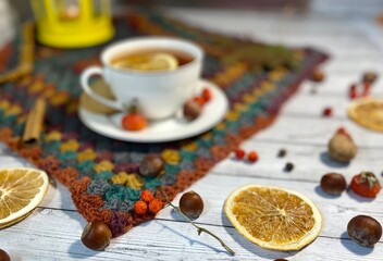 Cozy autumn photo with a cup of tea, flashlight, knitting, leaves and decor