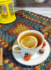 Cozy autumn photo with a cup of tea, flashlight, knitting, leaves and decor