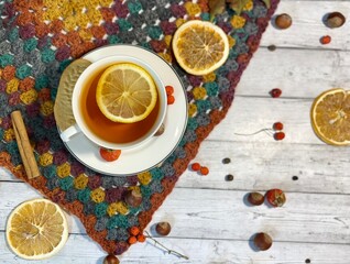 Cozy autumn photo with a cup of tea, flashlight, knitting, leaves and decor