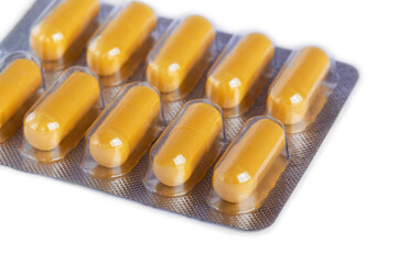 Yellow medical pills on a white background. Pills in plastic packaging.