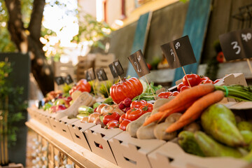 Detailed view of organic agricultural fresh produce in cardboard boxes placed on greenmarket stands...