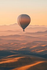 Fototapeta premium A single hot air balloon floating above rolling hills where the balloon and hills are created using large smooth shapes 