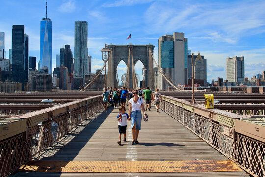 Mum and little kid posing in the amazing Brooklyn bridge in NYC.