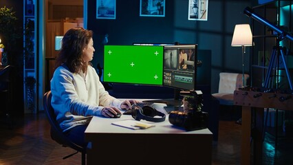 Video editor using editing software on green screen monitor to upgrade footage shot, commissioned...