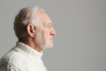 Sad senior man isolated on gray background. Studio portrait. Dementia and Alzheimer's disease concept. Memory loss awareness. Banner with copy space