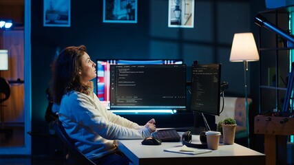 IT specialist working from home, testing and deploying programs using augmented reality. Programmer checking code on computer monitor and AR visualization, sitting at desk chair in apartment, camera A