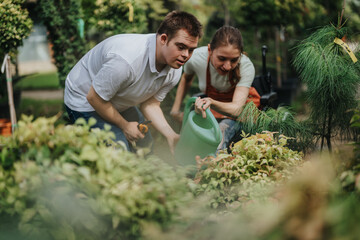 A male with Down syndrome and a female in a wheelchair enjoying gardening. They collaborate...