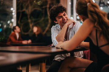 A young man and woman share laughter and conversation at a charming restaurant setting, creating a lively and engaging atmosphere.