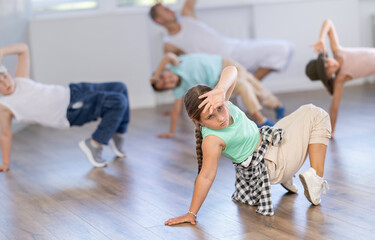 Group of active children dancers having break dance training at dance studio