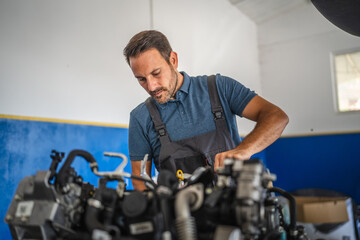 Car mechanic work on car engine with wrench in a garage setting