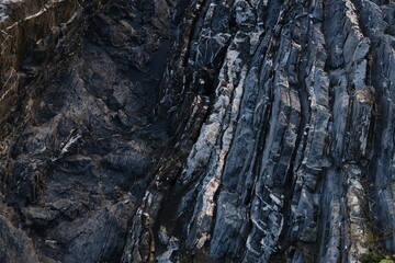 Black and white beach with a huge rock and sea waves. Rock and stone texture