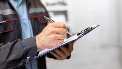 Auto check, car service shop concept. Automobile repairman writing job checklist on clipboard, mechanic checking engine to estimate repair machine, inspecting maintenance by engineer at vehicle garage