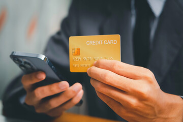 Close up Male hands holding credit card and smartphone, man paying online, credit card shopping, using banking service, entering information, shopping, ordering in internet store, doing secure payment