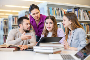 Obraz premium Group portrait of smiling positive engaged in research, working together in public library