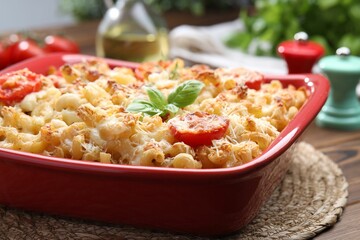 Delicious al forno pasta in baking dish on wooden table, closeup