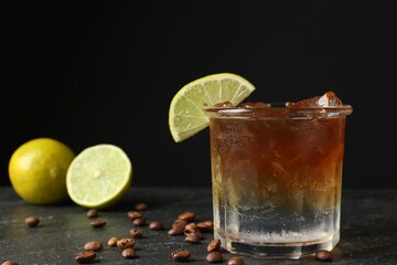 Refreshing espresso tonic drink with slice of lime and coffee beans on dark table, closeup