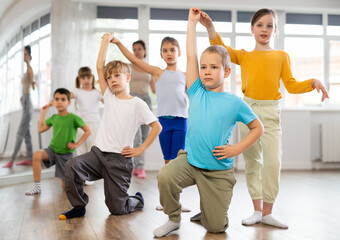 Preteen girls and boys learn to dance classical dances in a choreographic studio