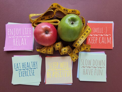 Colorful sticky notes with important life messages: eat healthy, keep calm, sleep well, be positive, smile... A set of inspirational reminder notes with measuring tape and apples. Healthy lifestyle