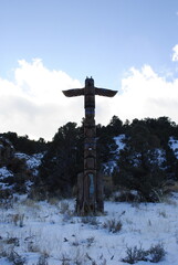 Totem pole against snowy mountain backdrop