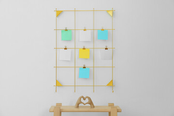 Mood board with blank paper notes and decorative figure in shape of hands making heart on wooden ladder near white wall