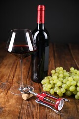 Wing corkscrew, cork, bottle of wine, glass and grapes on wooden table