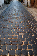 Pavement road. Stone cladding. Rough brick road. Cobblestone pavement background. Textured background. Sidewalk. Road. Old cobblestone road.