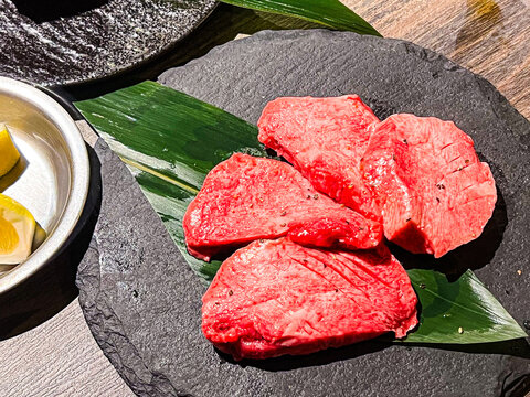 Succulent slices of raw gyutan, Japanese beef tongue, prepared for yakiniku. This popular Japanese dish offers a unique texture and flavor, often enjoyed at traditional BBQ restaurants.